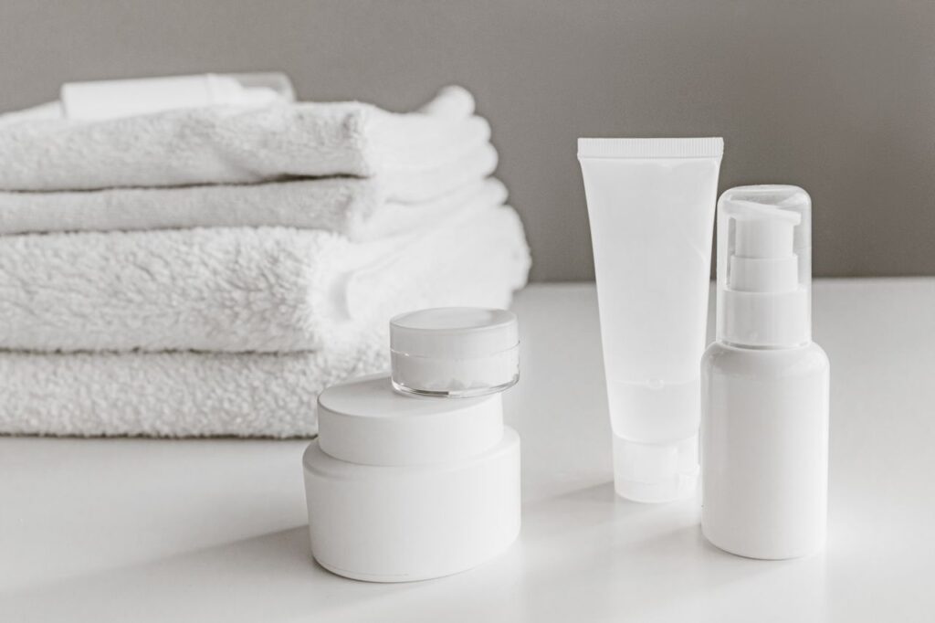 automotive Minimalist arrangement of white skincare products and towels for a modern aesthetic.